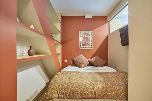- une chambre avec un lit aux murs orange dans l'établissement Résidence Center of Paris by Studio prestige, à Paris