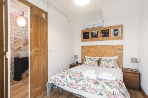 um pequeno quarto com uma cama e uma janela em GuestReady - Guimarães Urban Retreat em Guimarães