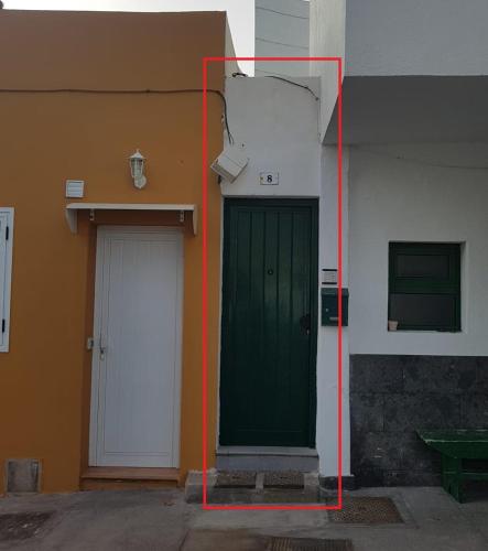 a green door next to a building with two doors at La Bajada in Güimar