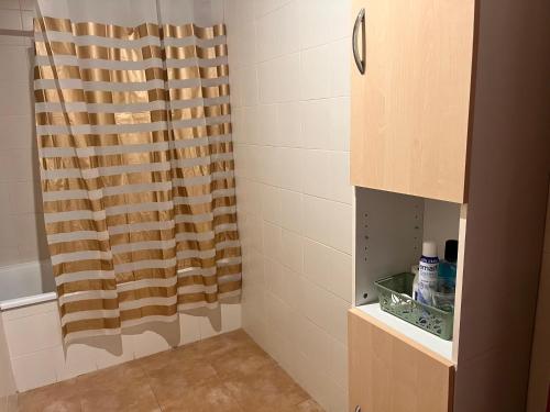 a shower with a curtain in a bathroom at La oliva in Cáceres
