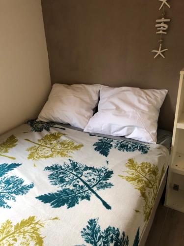a bed with a green and white blanket on it at Vakantiehuis in Katwijk aan zee in Katwijk aan Zee