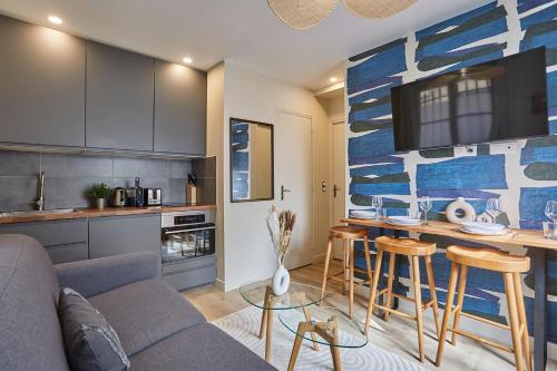 un salon avec un canapé et une cuisine dans l'établissement Résidence Center of Paris by Studio prestige, à Paris