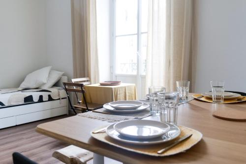 - une salle à manger avec une table et des assiettes dans l'établissement Bel appartement idéalement situé centre-ville Angers, à Angers