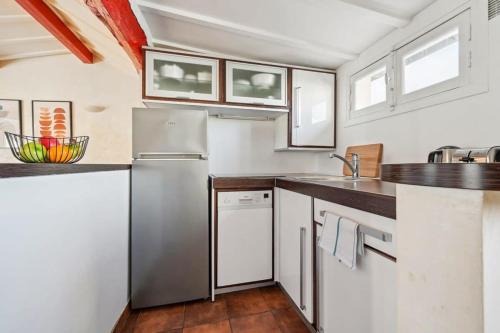 a kitchen with a stainless steel refrigerator and cabinets at Latin Quarter & Sorbonne - CityApartmentStay in Paris