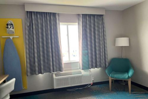 Days Inn & Suites by Wyndham of Morris في Morris: غرفة بها نافذة بها مشعاع وكرسي