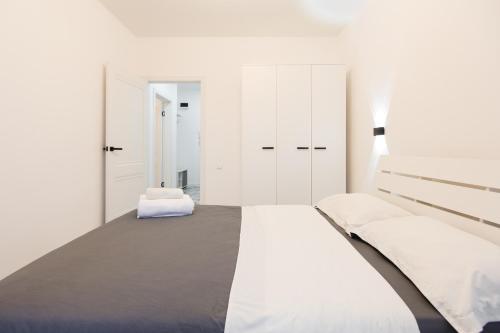 biała sypialnia z łóżkiem i białymi szafkami w obiekcie Уютная двухкомнатная квартира w mieście Kokczetaw