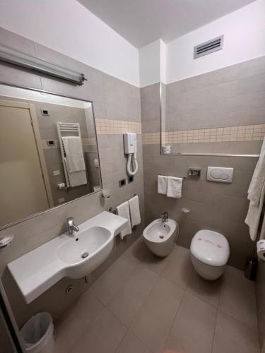 a bathroom with a sink and a toilet at Hotel Dante Family Spa Resort in Cervia