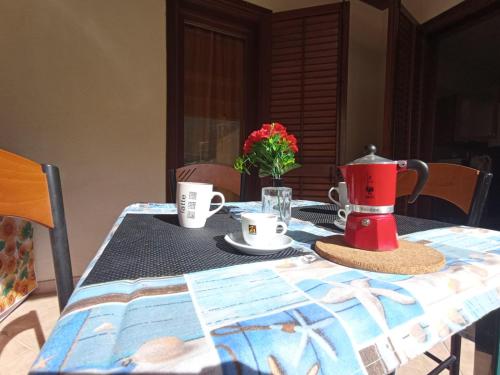 a table with a tea pot and cups on it at Sandro Apartment in Castellammare del Golfo