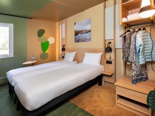 um quarto com uma grande cama branca num quarto em IBIS STYLES Rouen Parc Expos Zenith em Saint-Étienne-du-Rouvray