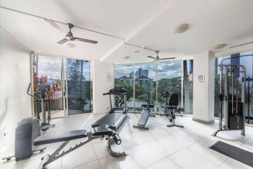a gym with treadmills and cardio equipment and windows at Paradise Island Resort & Gardens - Gold Coast Surfers Paradise in Gold Coast