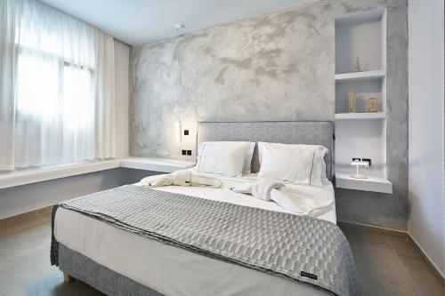 a bedroom with a large bed with white sheets at Sapphire Kythnos Suites in Mérikhas