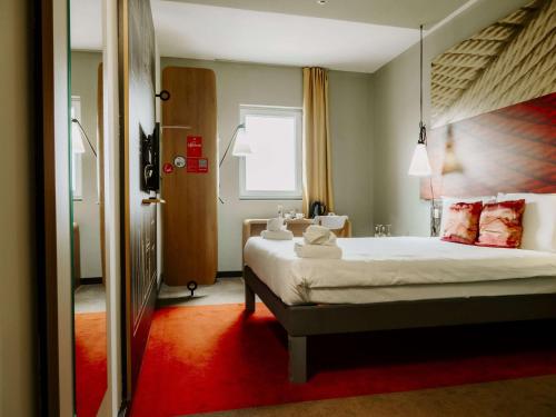 a bedroom with a large bed with a red carpet at Ibis Sofia Airport Hotel in Sofia