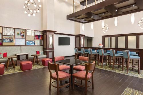 a restaurant with a bar with chairs and tables at Hampton Inn & Suites York South in York
