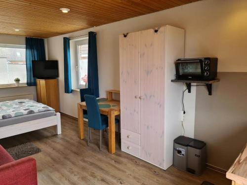 a bedroom with a bed and a desk with a television at Ferienwohnung ZWEI nähe Büsum in Oesterdeichstrich