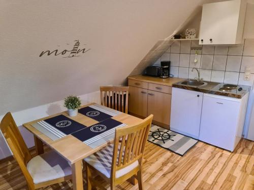 uma pequena cozinha com uma mesa e uma mesa e cadeiras em Ferienwohnung EINS nähe Büsum em Oesterdeichstrich