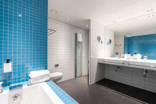 a bathroom with a tub and a toilet and a sink at Scandic Ishavshotel in Tromsø