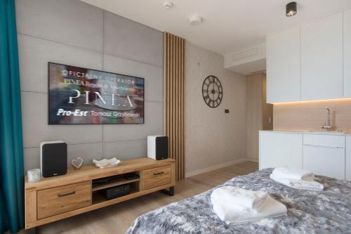 a bedroom with a bed and a dresser with speakers at Apartament Deluxe Sea View PINEA 606 in Pobierowo