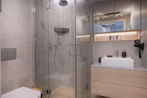 y baño con ducha y lavamanos. en Apartament Deluxe Sea View PINEA 606 en Pobierowo