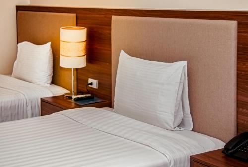 a hotel room with two beds with white pillows at Mường Thanh Grand Dien Bien Phu Hotel in Diện Biên Phủ