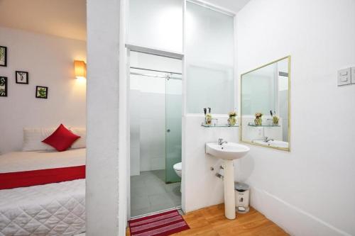 baño con lavabo, cama y espejo en PHÚ GIA BÙI VIỆN HOTEl en Ho Chi Minh