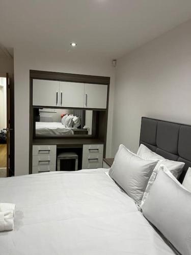 um quarto com uma grande cama branca com almofadas brancas em The Forest Haven Cottage - Free Parking & Wi-Fi em Whitefield