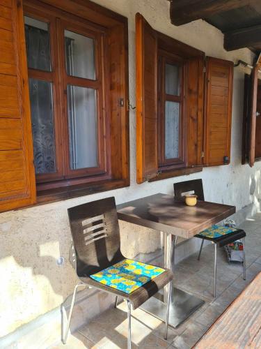 a wooden table and chairs in front of a house at GERENDÁS VENDÉGHÁZ in Mátraderecske