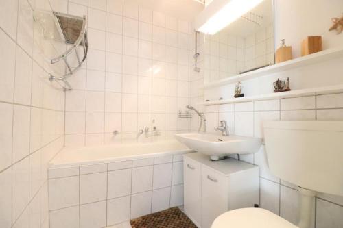 a white bathroom with a sink and a toilet at Frische-Brise-10-02 in Cuxhaven