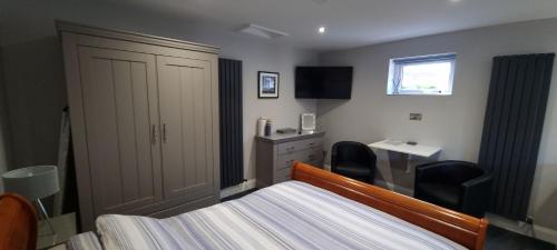 a bedroom with a bed and a dresser and a desk at The Nook in Rostrevor