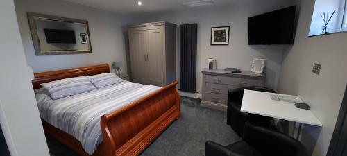 a bedroom with a bed and a desk and a television at The Nook in Rostrevor