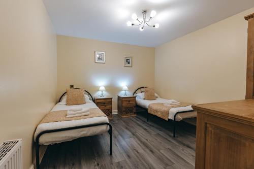2 Einzelbetten in einem Zimmer mit Holzböden in der Unterkunft Finest Retreats - Netley Hall - Lavender in Dorrington