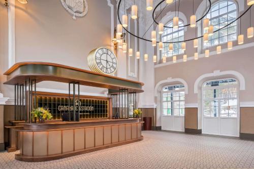 un vestíbulo con un reloj en la pared en Canfranc Estación, a Royal Hideaway Hotel - Gran Lujo en Canfranc-Estación