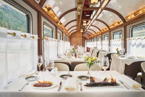 a dining car of a train with tables and chairs at Canfranc Estación, a Royal Hideaway Hotel - Gran Lujo in Canfranc-Estación