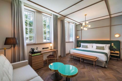 a hotel room with a bed and a couch at Canfranc Estación, a Royal Hideaway Hotel - Gran Lujo in Canfranc-Estación
