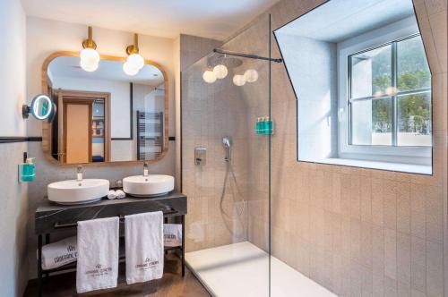 a bathroom with two sinks and a shower at Canfranc Estación, a Royal Hideaway Hotel - Gran Lujo in Canfranc-Estación