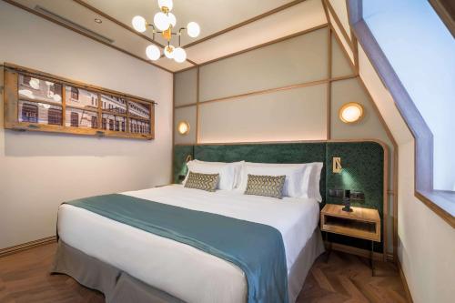 a bedroom with a large bed with a green headboard at Canfranc Estación, a Royal Hideaway Hotel - Gran Lujo in Canfranc-Estación