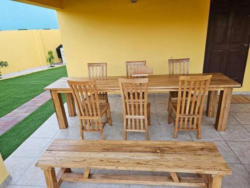 a wooden table and chairs and a wooden bench at Yellow Cunucu-4 Bedrooms House in Paraguaná