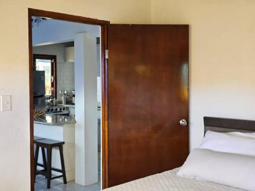 a door leading to a bedroom with a bed and a kitchen at Yellow Cunucu-4 Bedrooms House in Paraguaná