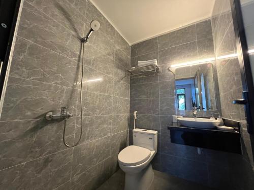 een badkamer met een douche, een toilet en een wastafel bij Happy House Moc Chau in Mộc Châu