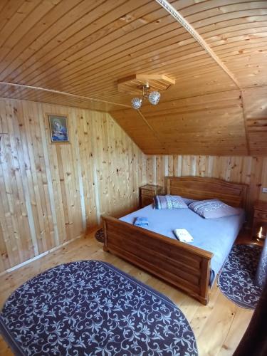 1 dormitorio con 1 cama en una cabaña de madera en На Пагорбі, en Mykulychyn