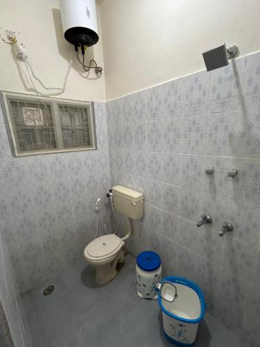 a bathroom with a toilet and a window at ABS Home Stay, 2Bed room AC Flats,Tirupati in Tirupati