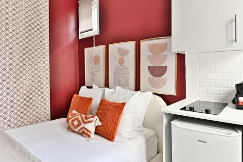 - un canapé blanc avec des oreillers dans la cuisine dans l'établissement Studio Cosy près de Montparnasse, à Paris