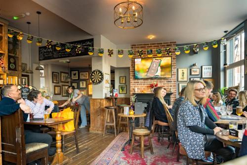 un grupo de personas sentadas en mesas en un restaurante en The Westgate en Winchester