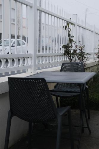 een tafel en 2 stoelen op een balkon bij GuestReady - Monochromatique near the port in La Rochelle