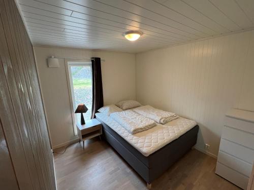 a small bedroom with a bed and a window at Moderne feriehus i Bud in Bud