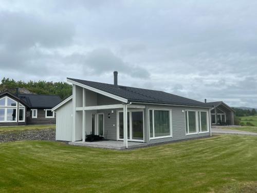a small white house with a large yard at Moderne feriehus i Bud in Bud