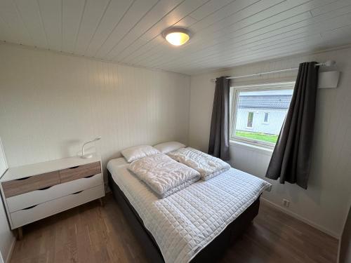 ein kleines Schlafzimmer mit einem Bett und einem Fenster in der Unterkunft Moderne feriehus i Bud in Bud