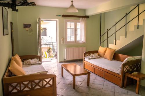 a living room with a couch and chairs and a staircase at Chrisanthi Apartments in Syvota