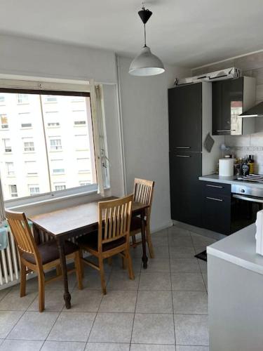 une cuisine avec une table et des chaises dans une cuisine dans l'établissement Chambre double privée, Appartement partagé, à Annemasse