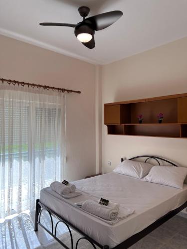 a bedroom with a bed with a ceiling fan at Sea view relaxing home in Mesimvría