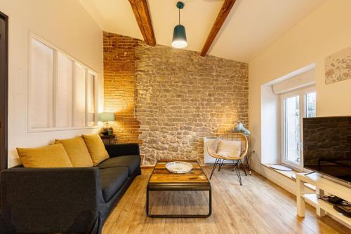 a living room with a couch and a brick wall at GuestReady - Lovely Apt in The Heart of La Rochelle in La Rochelle